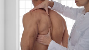 osteopathy, manual therapy, acupressure. Therapist doing healing treatment on man's back.